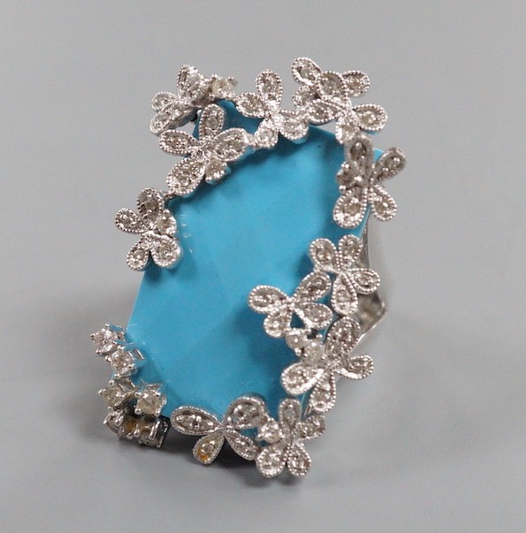 A large modern 14k white metal, turquoise and diamond chip set dress ring, the rectangular 'chequerboard' top cut turquoise weighing approx. 18.25ct, size M, gross weight 15 grams.